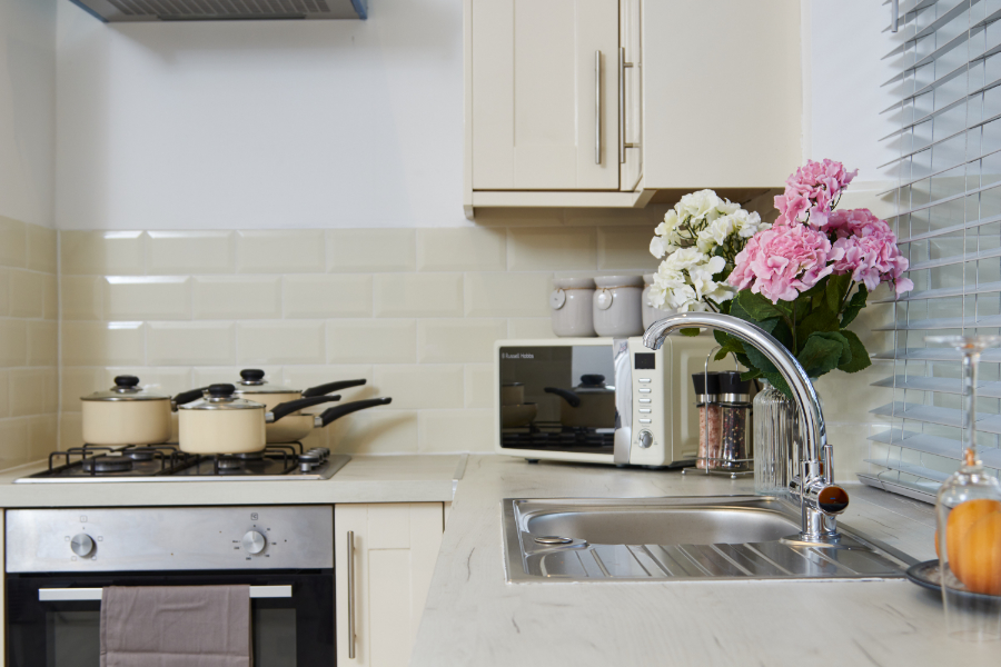 Close up of a remodelled modern kitchen corner with cream units and metro tile splashbacks, finished to high quality standard