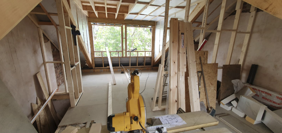 Mid loft conversion project: the dormer has been built but windows are yet to go in. Timber room partitions are in progress